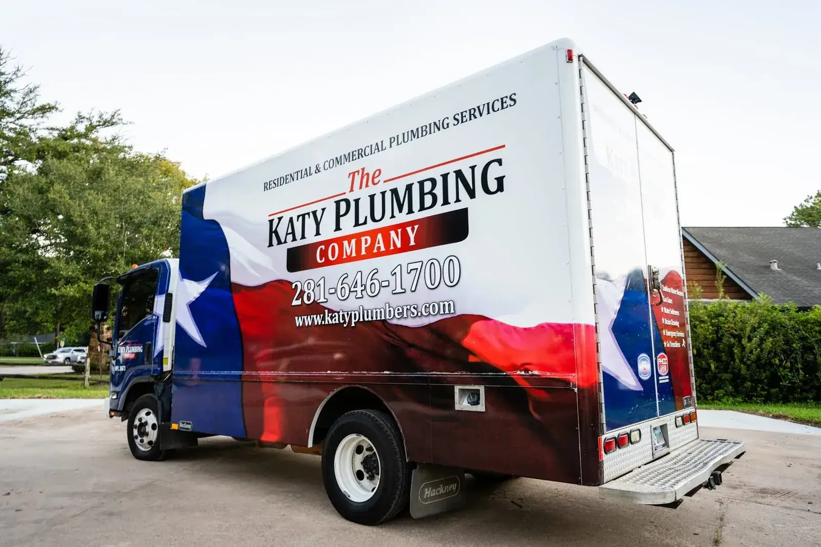 A The Katy Plumbing Company Heating & Air box truck outside a Katy home